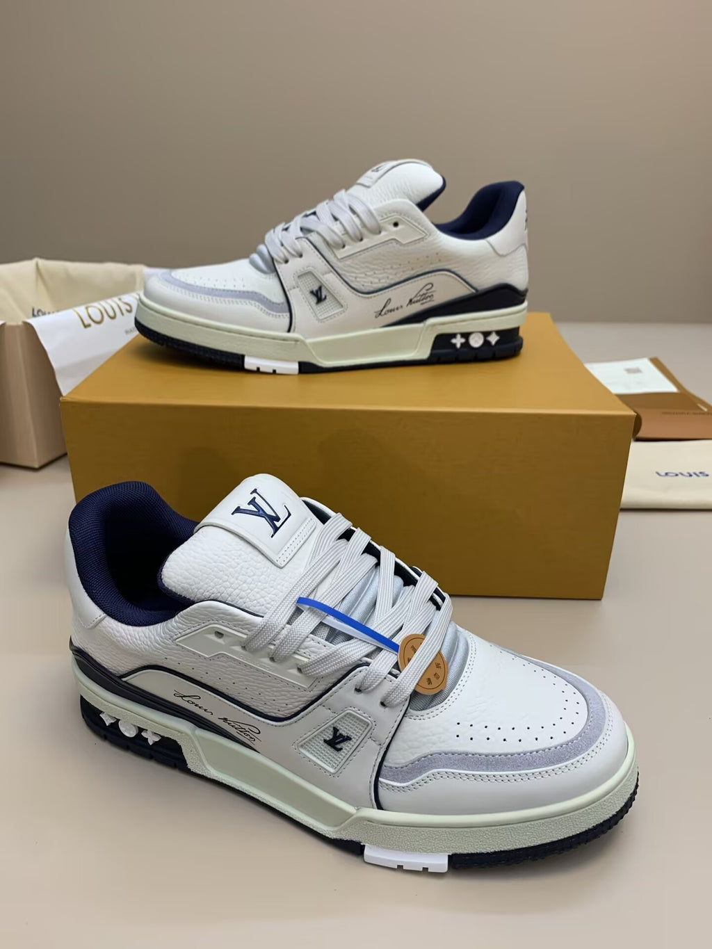 White low-top sneakers with navy and gray accents