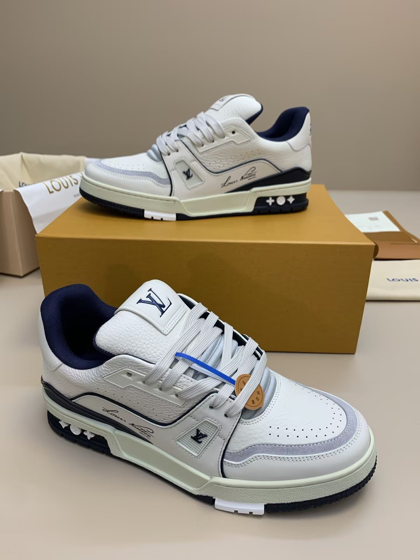 White low-top sneakers with navy and gray accents