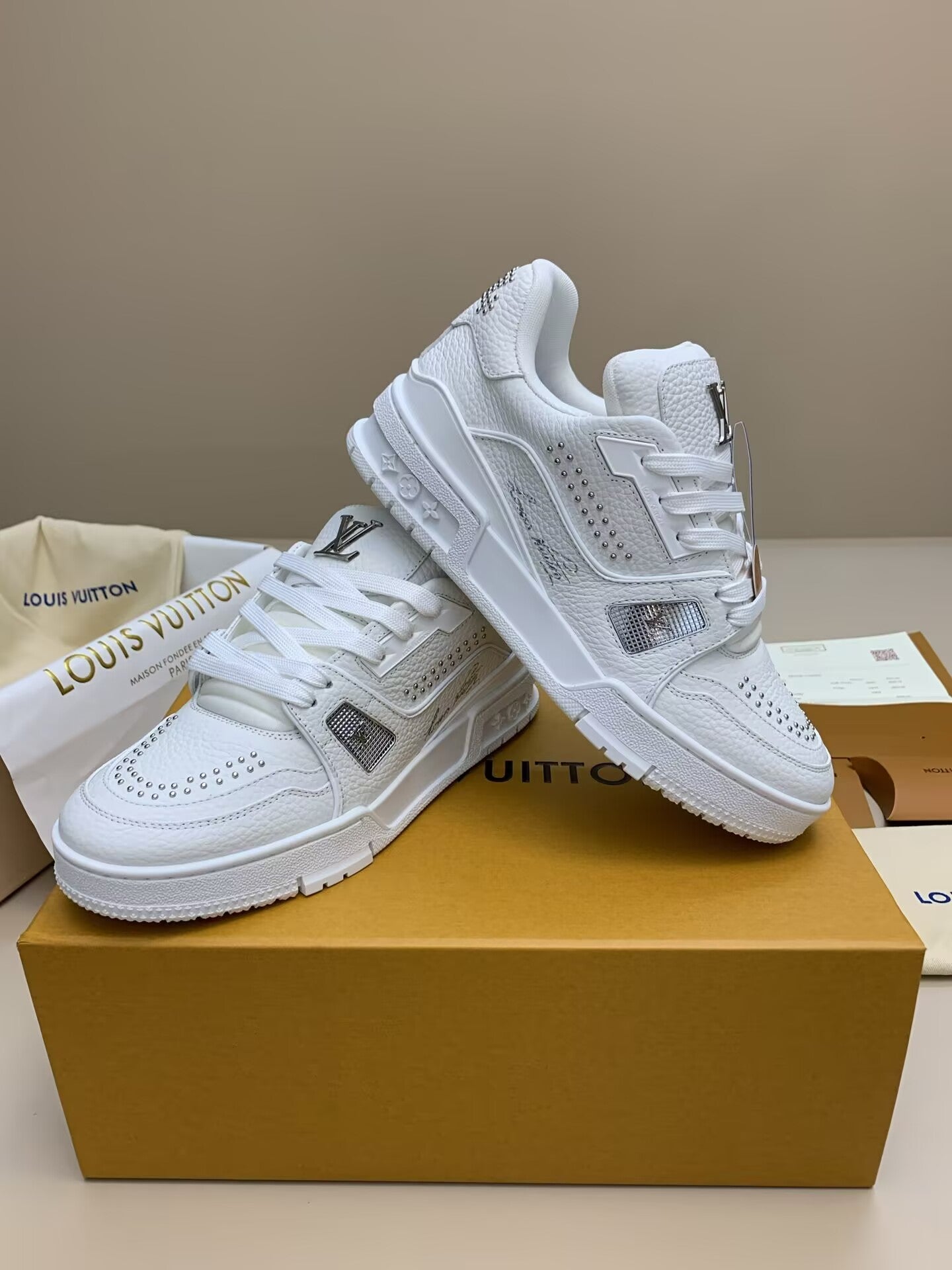 White low-top sneakers with silver studs