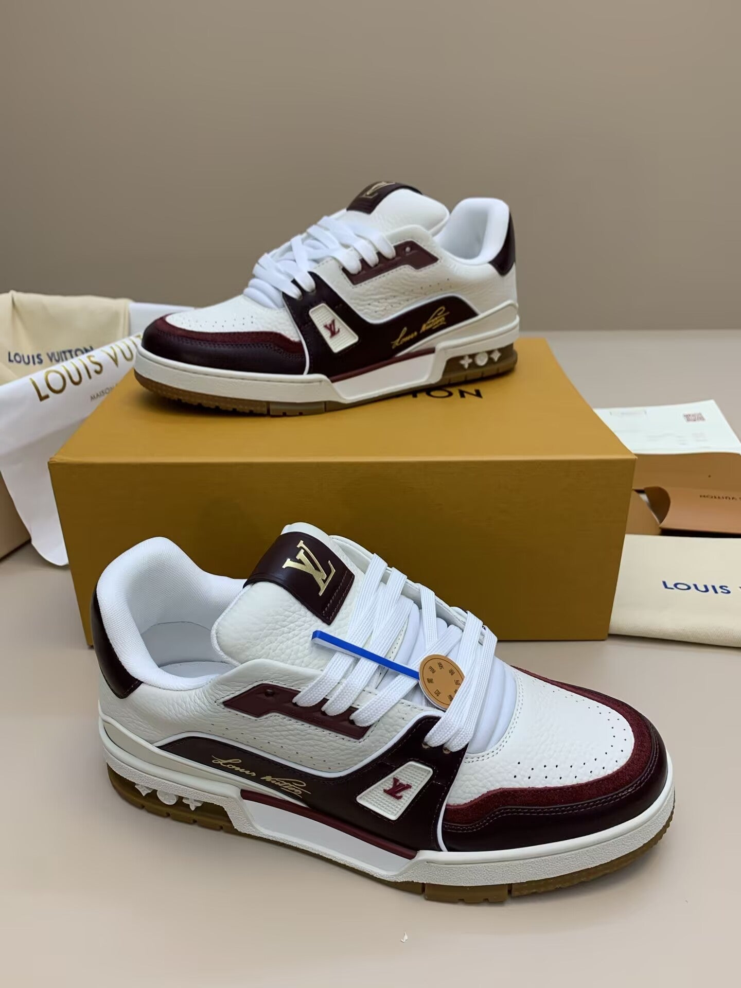 White and burgundy low-top leather sneakers with perforated toe